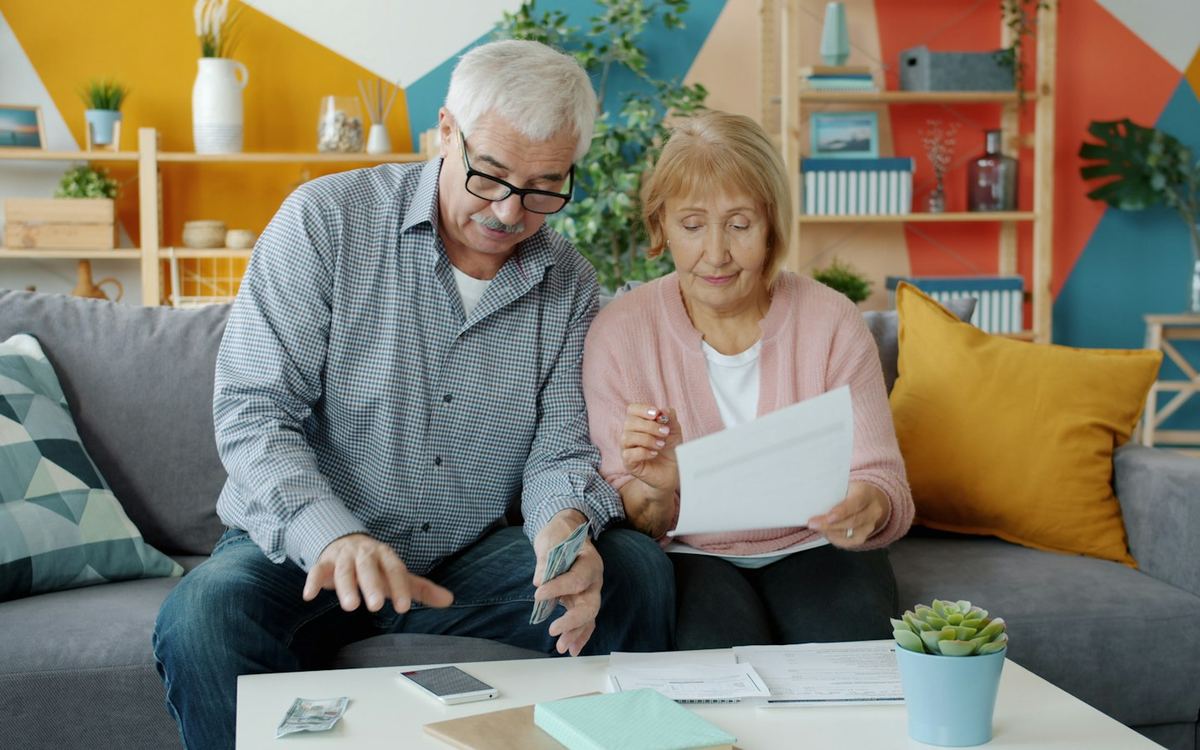 Pareja revisando documentos financieros en su casa